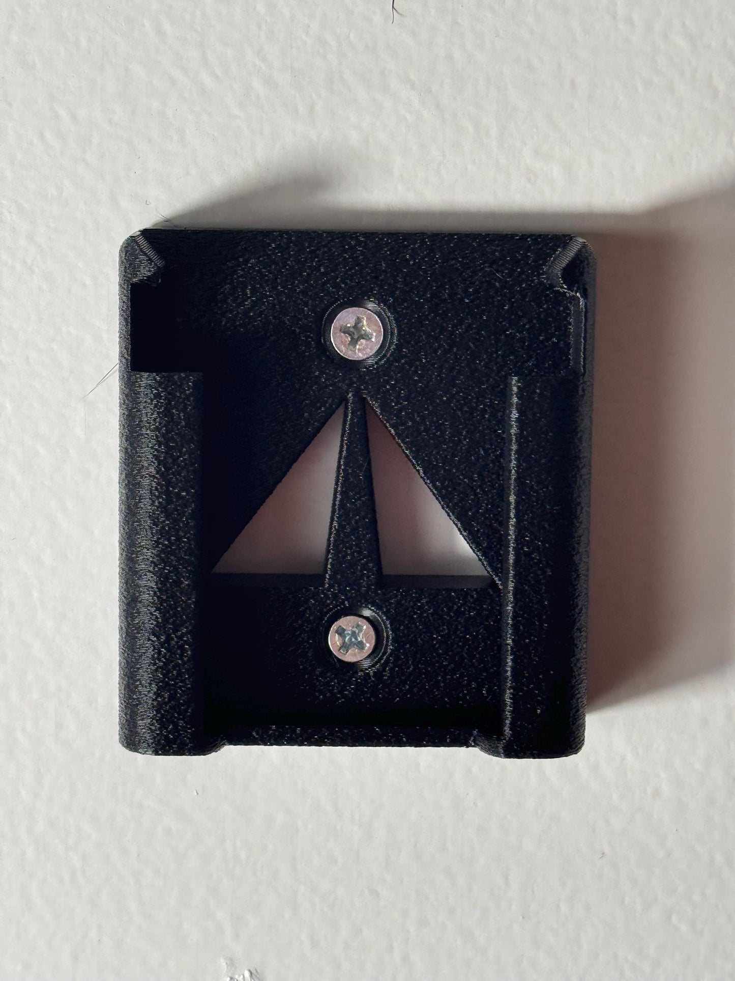 M18 battery holder mounted on a white wall with screws