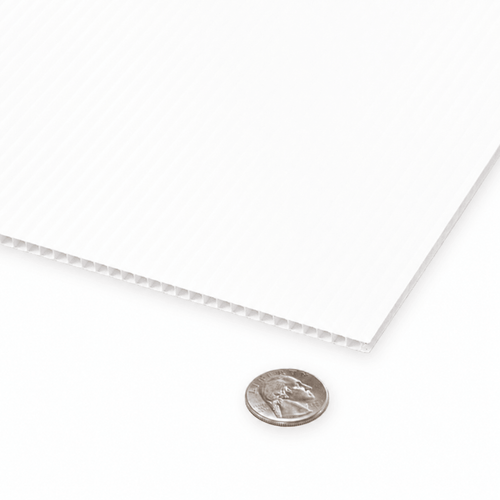 A close-up of a white textured sheet with a ribbed corrugated edge, shown on a white background with a US quarter coin for scale.