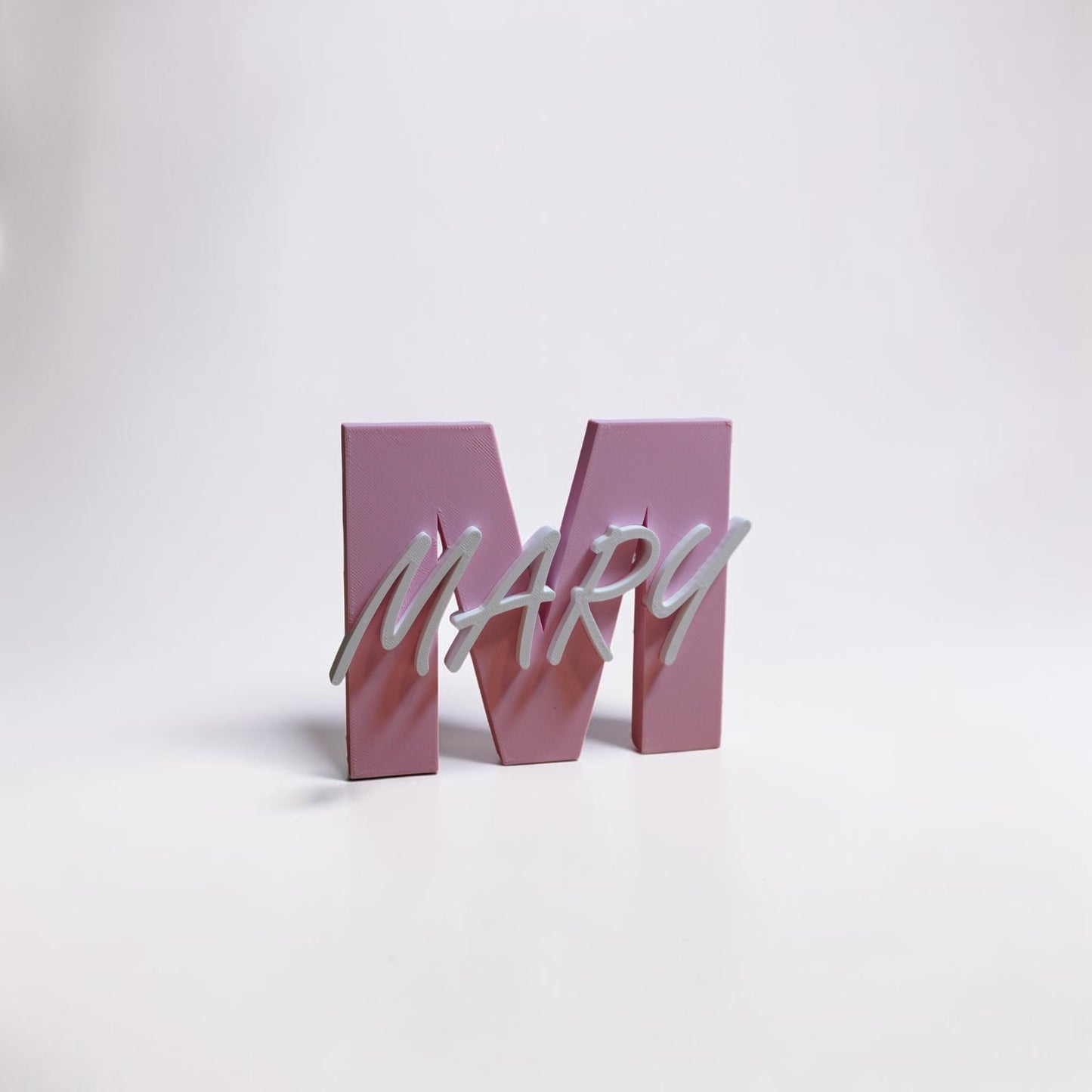 Pink letter 'M' with 'MARY' in white on a white background