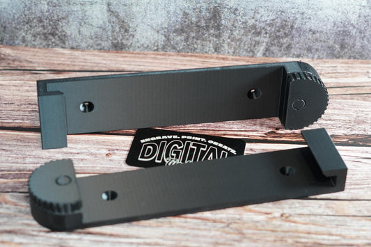 Set of 3D-printed wall brackets for track saw rails shown with mounting holes on wooden background