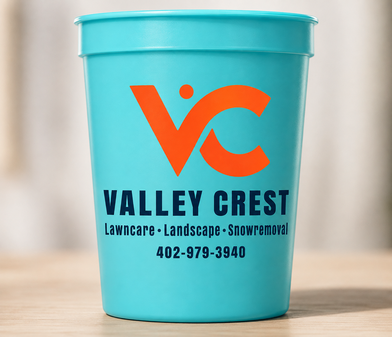 Bright aqua 16 oz custom plastic cup printed with the Valley Crest lawn care logo