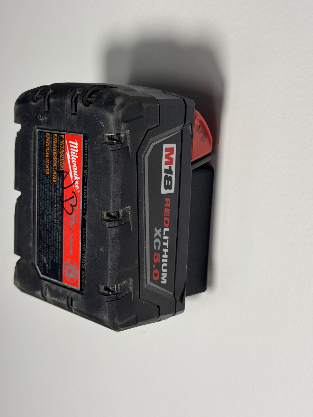 Milwaukee M18 battery clipped securely into wall holder (etsy image id: 6523477954)