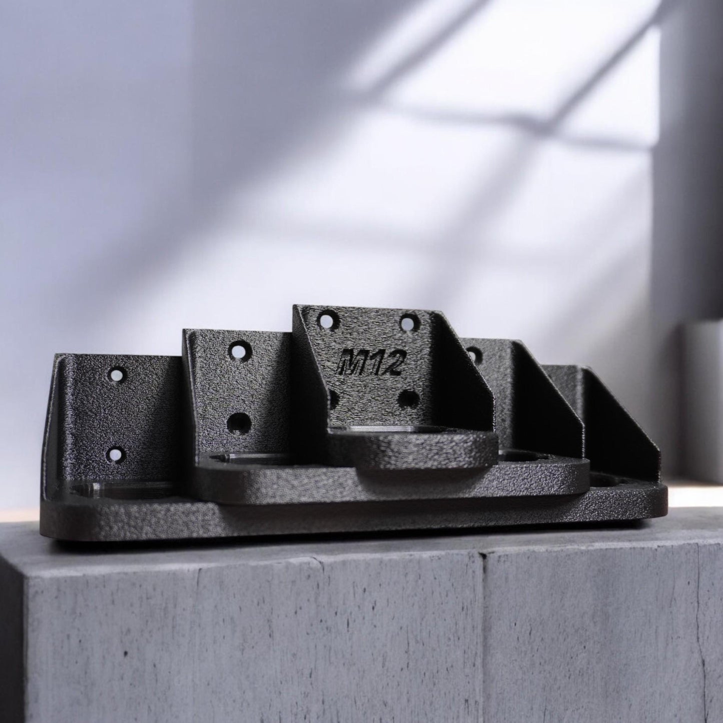 Wall-mounted M12 battery holder made from PETG, featuring multiple slots for securely storing M12 batteries. The holder is mounted on a wall, showcasing its compact and organized design. (etsy image id: 6528013400)