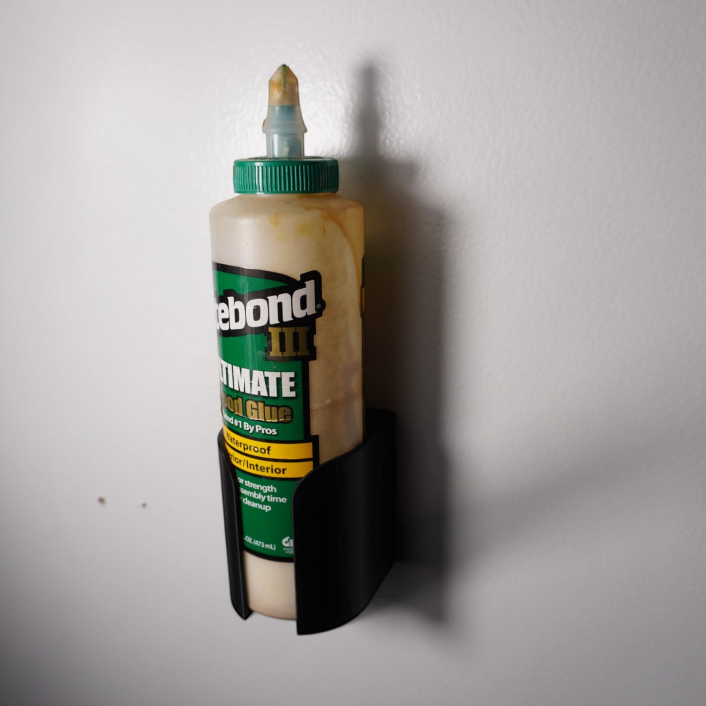 3D-printed glue bottle holder, made from PETG plastic. Designed to securely hold your glue bottle upside-down for smooth flow or upright for stability, it’s perfect for woodworkers (etsy image id: 6577613525)