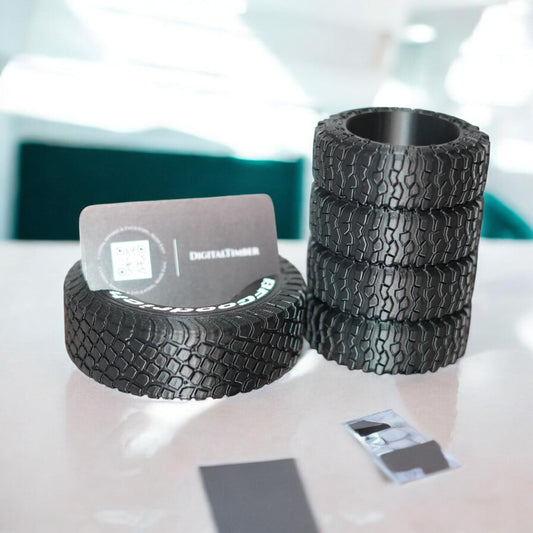 3D printed tire pen holder and business card stand in black, styled with realistic off-road tread details. Perfect desk organizer gift for auto lovers, mechanics, or off-road fans. Made by DigitalTimber. (etsy image id: 6741719764)