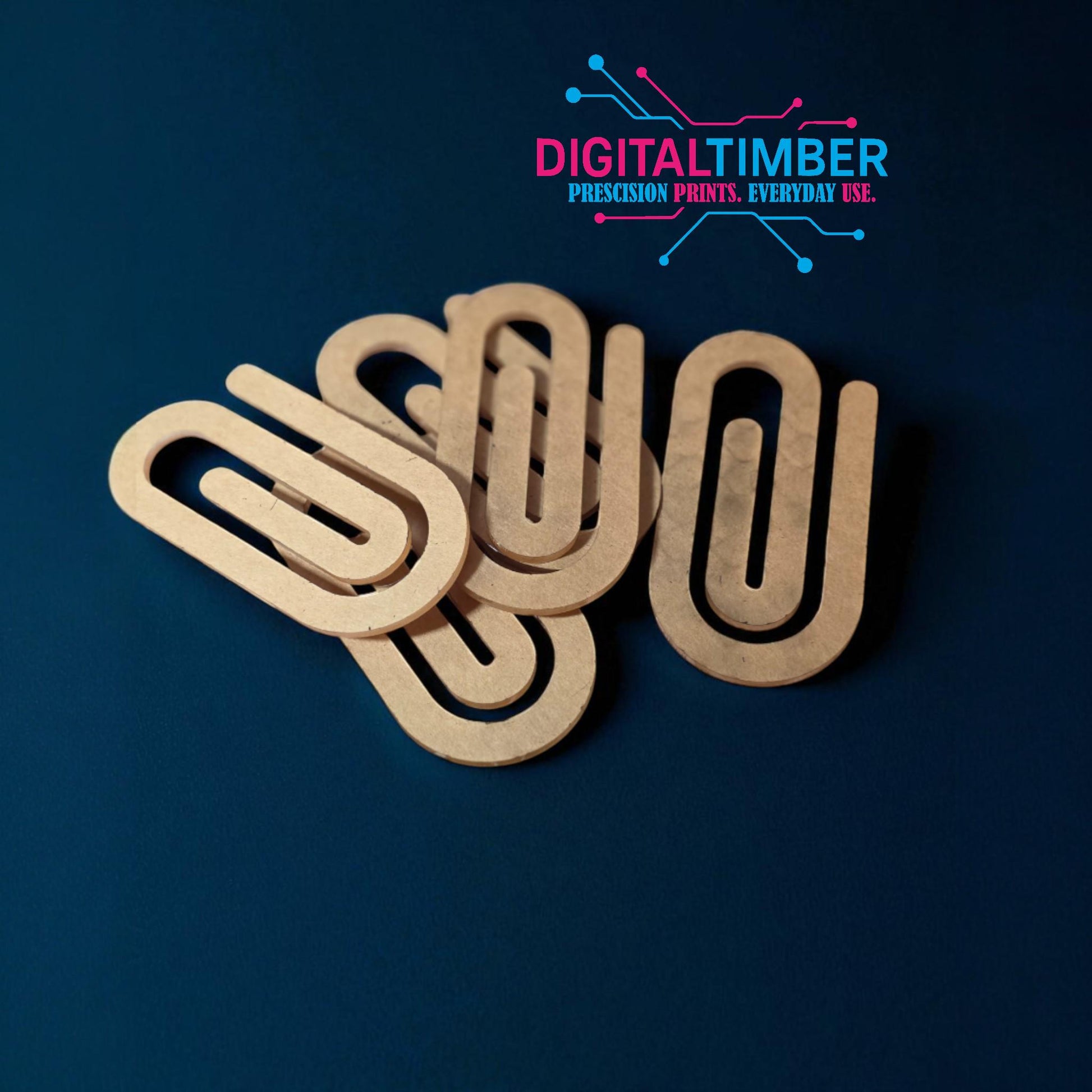 Group of sublimation-ready clear acrylic paper clip shapes spread out on a dark blue background (etsy image id: 7120468207)
