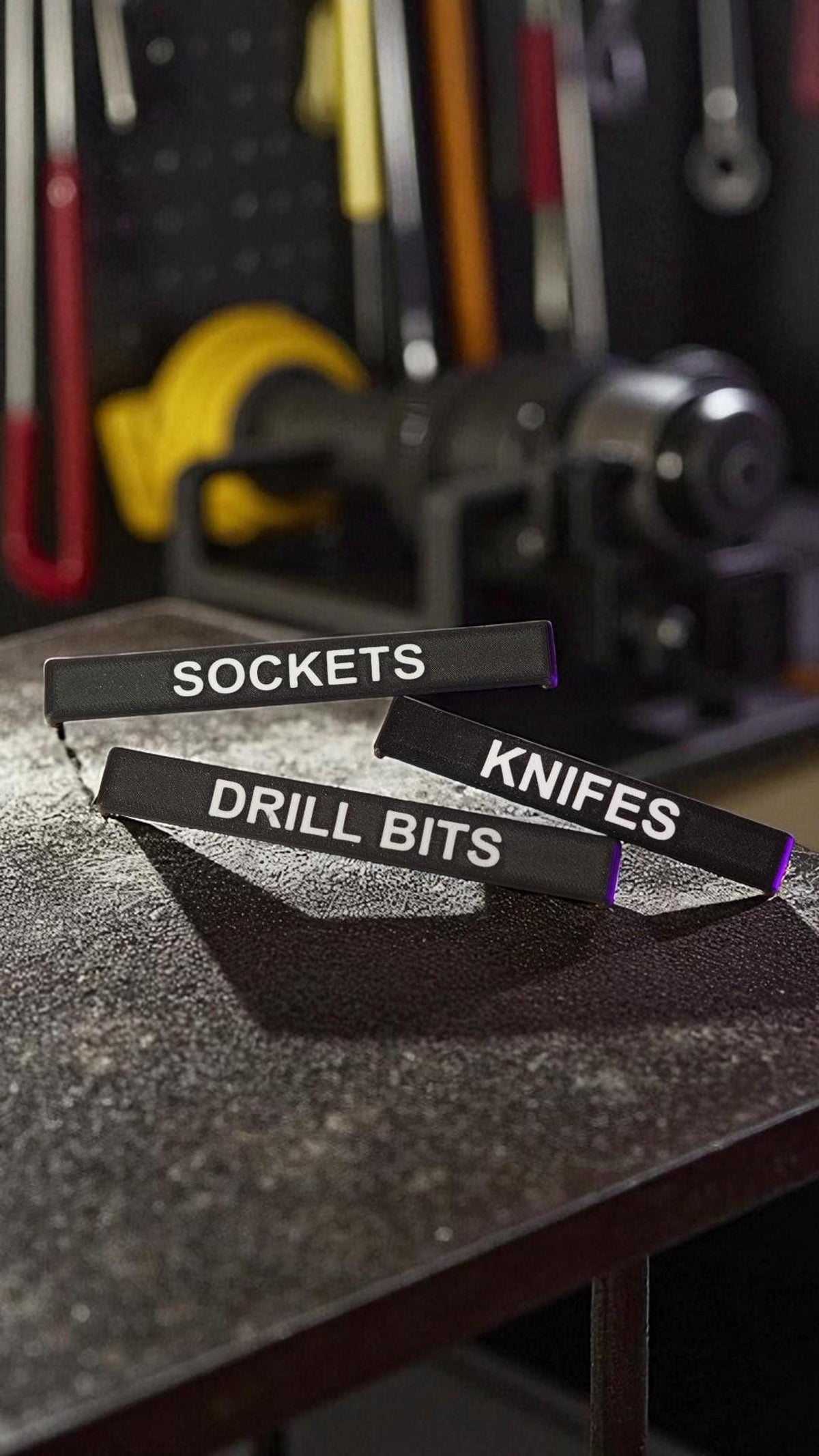 Three black labels with white text, reading "SOCKETS," "DRILL BITS," and "KNIVES," are arranged on a dark, textured surface. __etsy:8313067054
