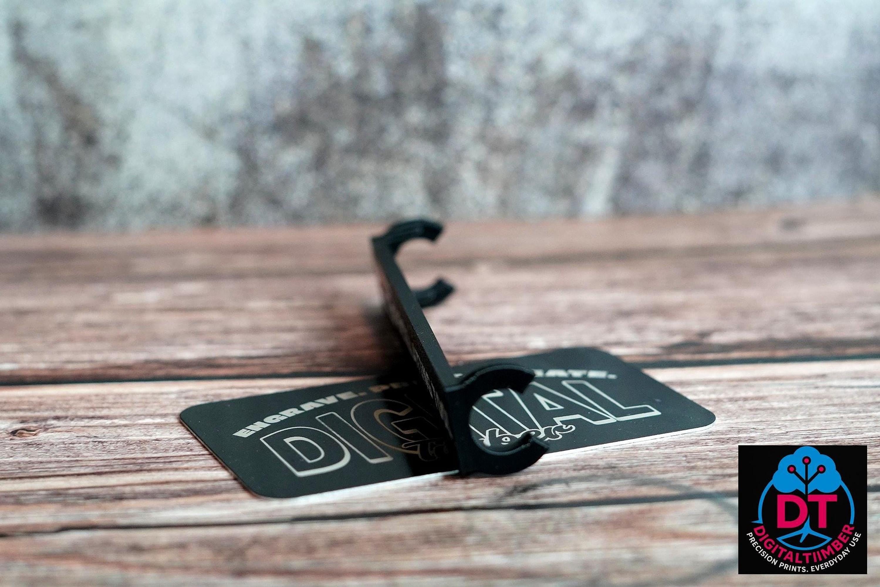 A black plastic label clip stands on a black card that reads "DIGITAL" in white, on a wooden surface. __etsy:8360985633