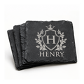 Stack of personalized black slate coasters engraved with a family crest, initial H, and the name Henry.