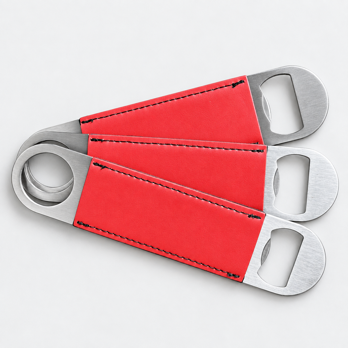 Ruby leatherette bottle openers before custom UV printing, light gray background