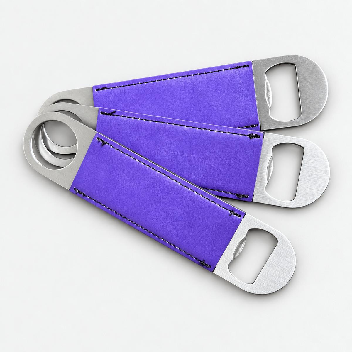Violet leatherette bottle openers before custom UV printing, light gray background