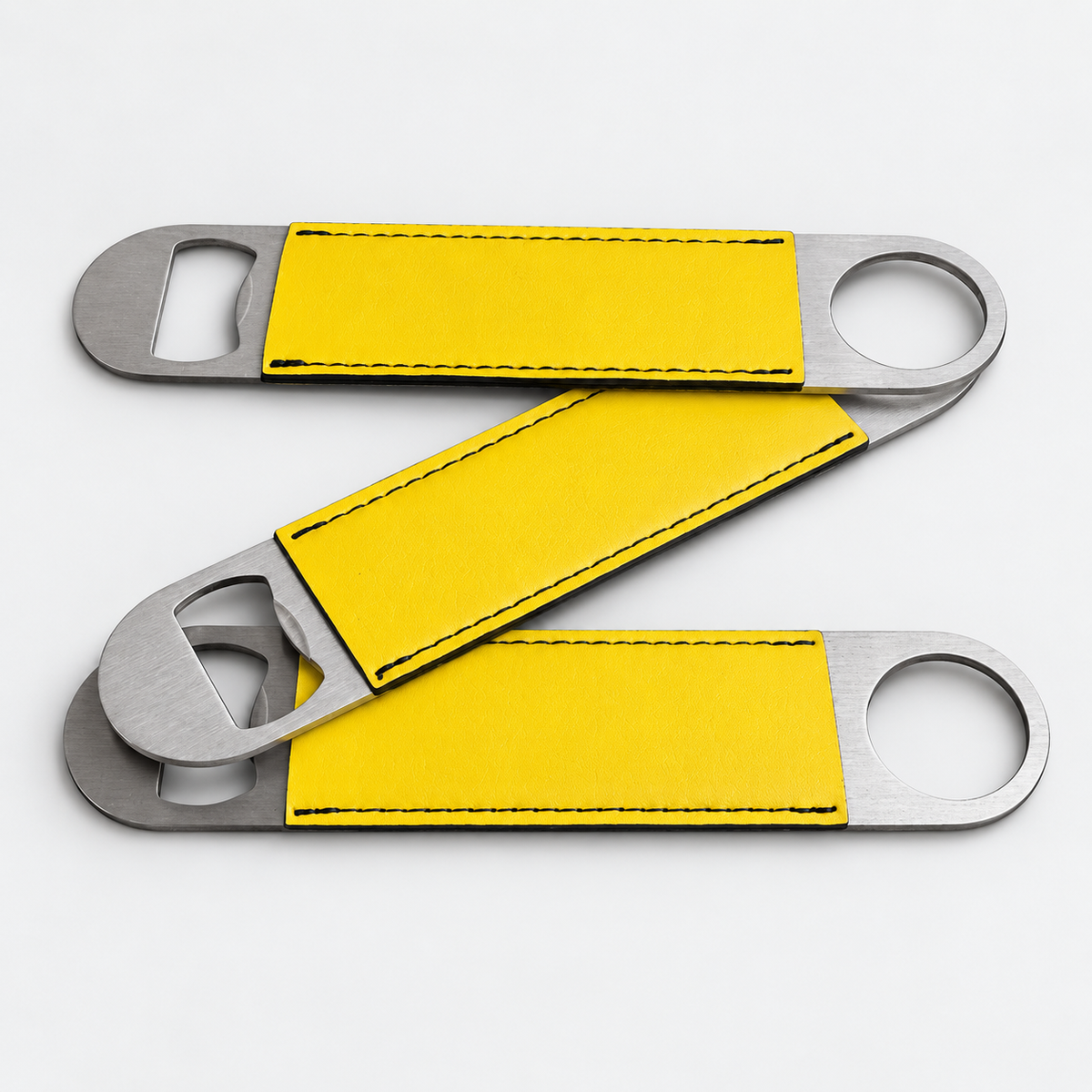 Yellow leatherette bottle openers before custom UV printing, light gray background